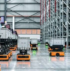 Robot pengangkut di dalam pusat agihan. Gambar dari kulit prospektus; prospektus tak labelkan lokasinya, tapi pusat agihan utama BCG ialah pusat separa automatik di Bukit Raja, Klang, yang simpan 31.7% stok runcit dan guna 80.2% kapasiti.